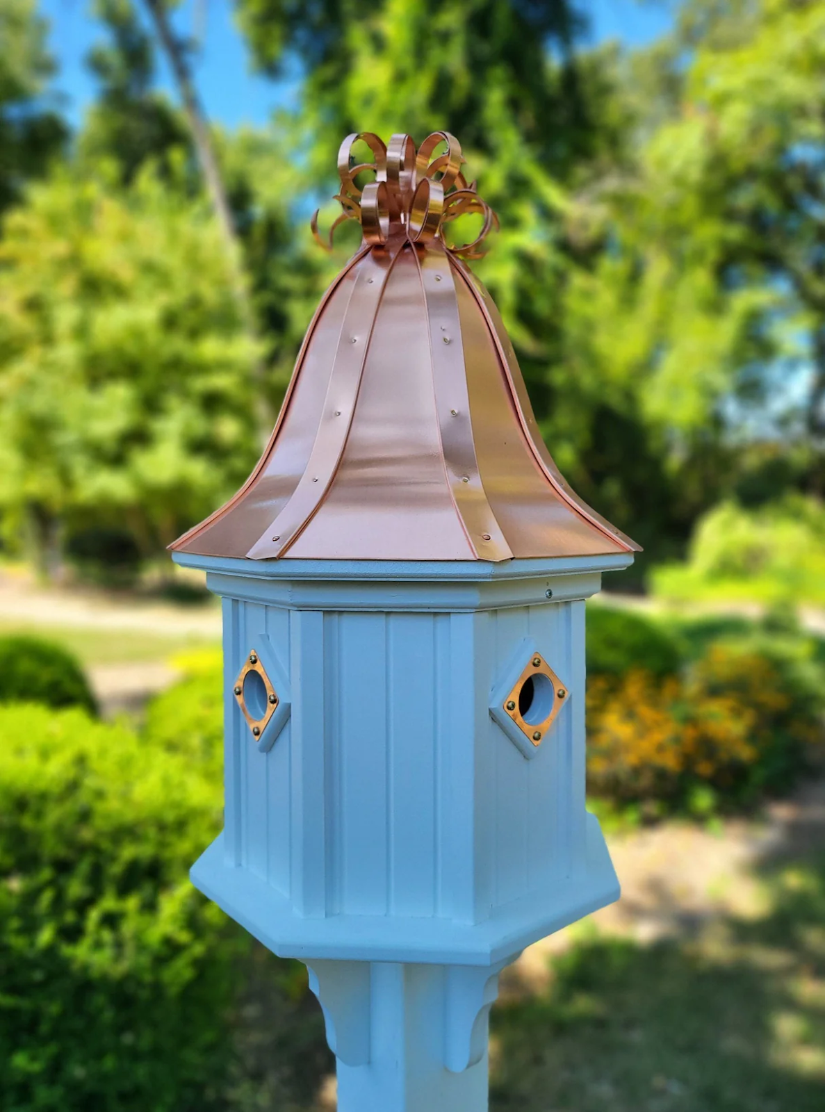 Extra large copper bird house with a bell-shaped roof and curly copper top, featuring four nesting compartments and weather-resistant construction.