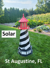 May include: A black and white striped lighthouse with a red roof. The lighthouse is solar powered and has a light inside. The lighthouse is on a green lawn with the words &#39;Solar&#39; and &#39;St. Augustine, FL&#39; in white text.