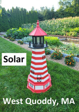 May include: A red and white lighthouse with a black roof and a solar panel on top. The lighthouse is in a garden setting with green grass and flowers. The text &#39;Solar&#39; is below the lighthouse and the text &#39;West Quoddy, MA&#39; is below the text &#39;Solar&#39;.